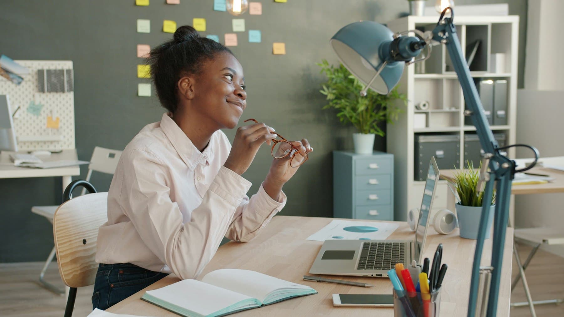A team member smiling at her desk