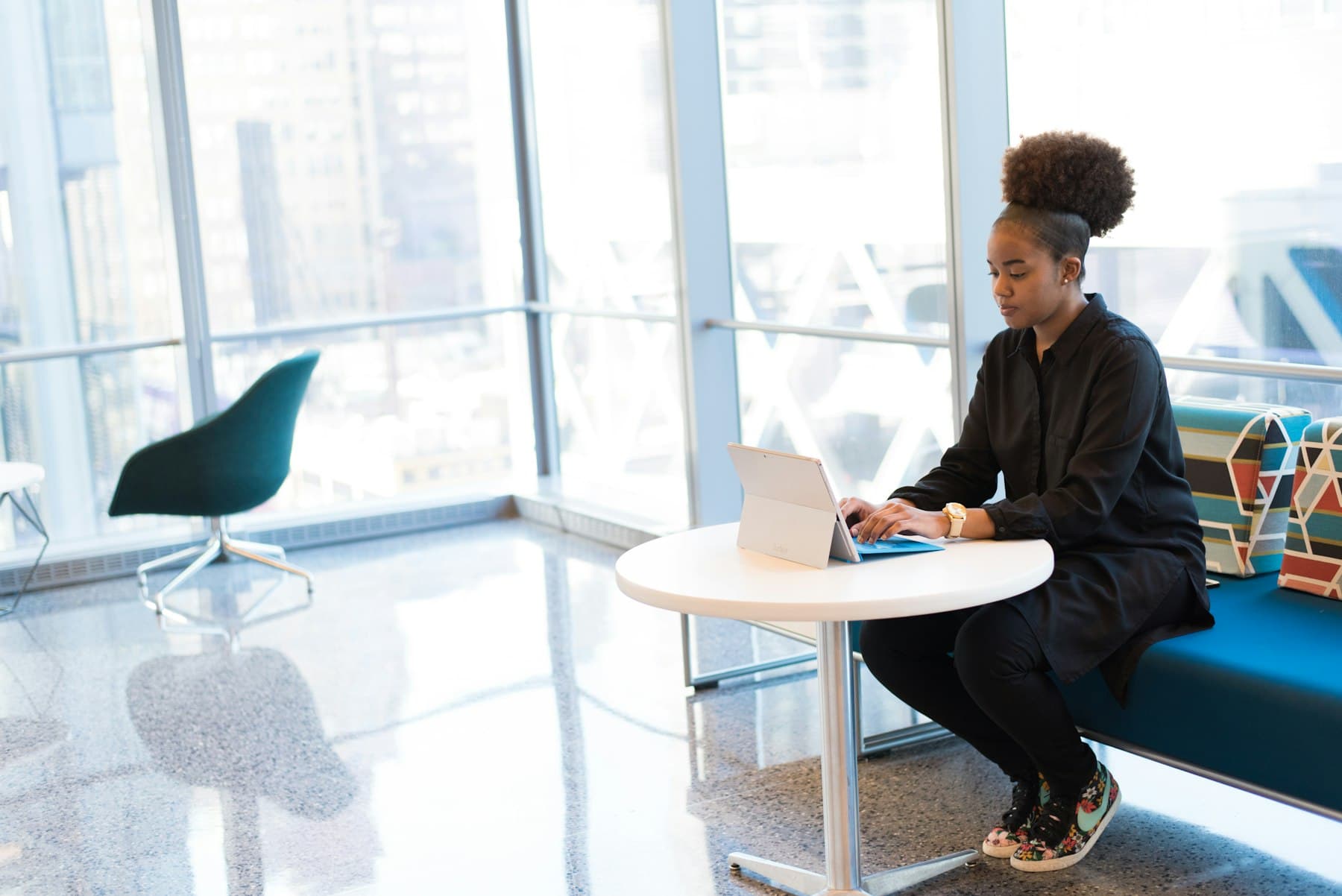 A woman working on a tablet in a bright office